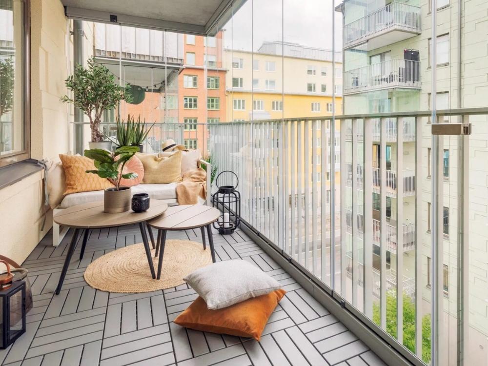 Ban công chung cư với tiểu cảnh xanh, ghế gỗ và sàn gỗ nhựa composite