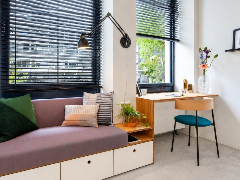 Băng ghế sofa tích hợp ngăn kéo nối liền bàn làm việc bên cửa sổ