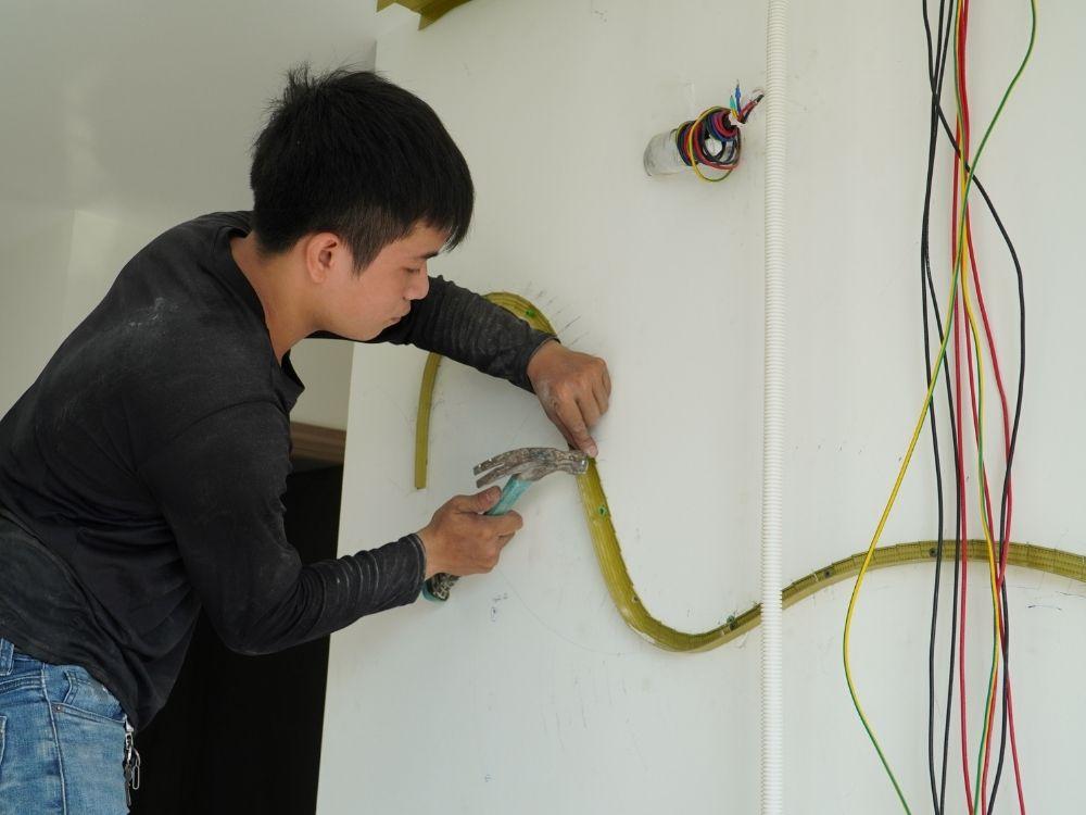 Đội thợ đang đo đạc và xử lý bề mặt trong quá trình thi công phần thô phòng ngủ