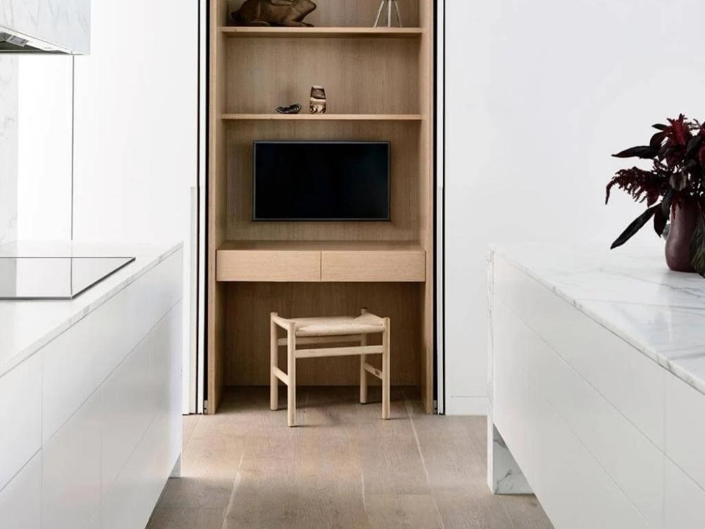 Góc làm việc khác tại tầng 1 được bố trí tinh tế với bàn gỗ, kệ lưu trữ tối ưu và điểm nhấn cây xanh nhỏ