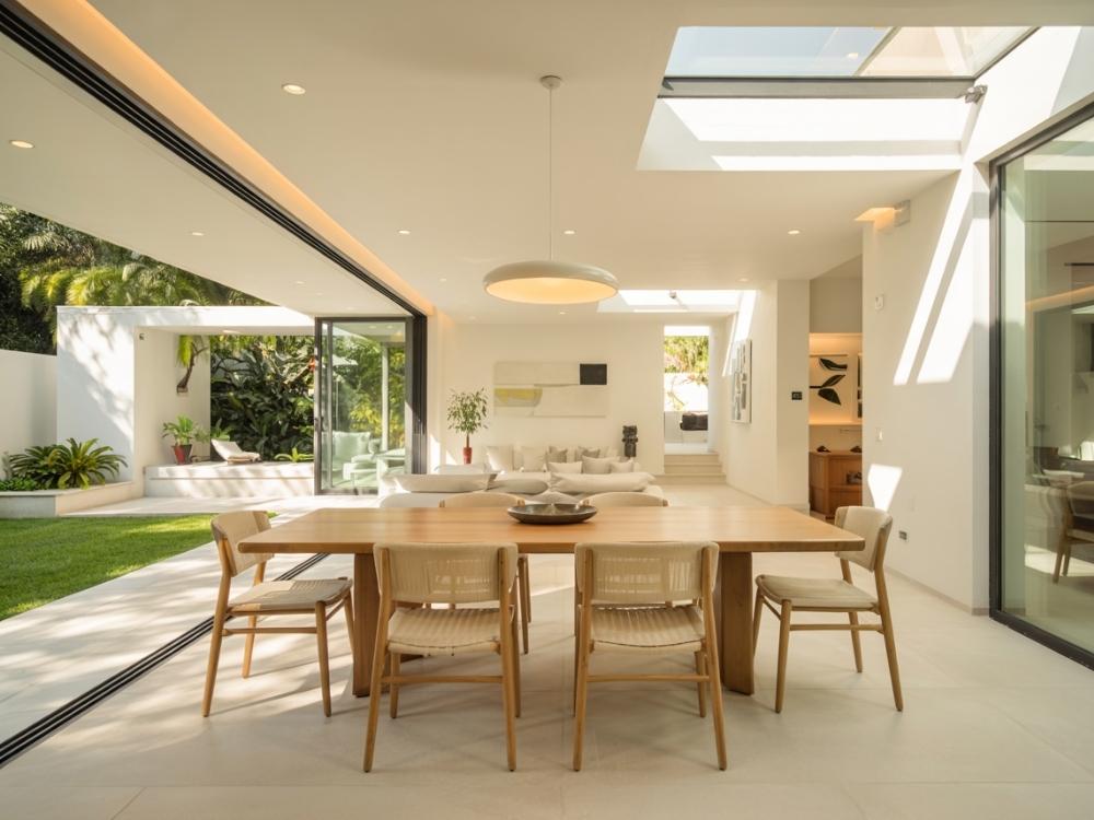 Không gian sống mở với tường kính, giếng trời và bảng màu sáng, tạo cảm giác hiện đại và thoáng đãng