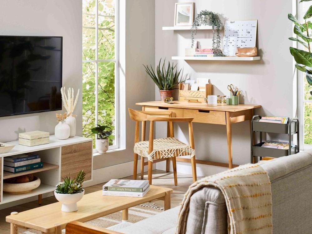 Phòng khách chung cư 75m2 với sofa xám, bàn trà gỗ và góc học tập/làm việc chung cho gia đình tạo không gian sinh hoạt thoải mái