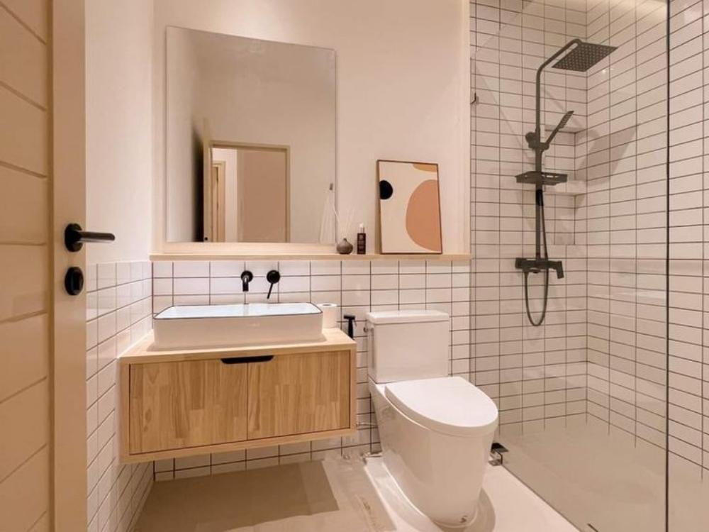 Phòng vệ sinh chung cư 50m2 với bồn rửa gốm sứ, vòi sen tối giản và gạch trắng