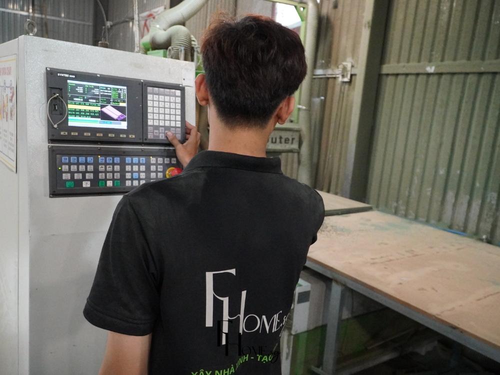 Người thợ lành nghề đang gia công vật liệu nội thất bằng máy hiện đại, đảm bảo độ chính xác, an toàn và chất lượng