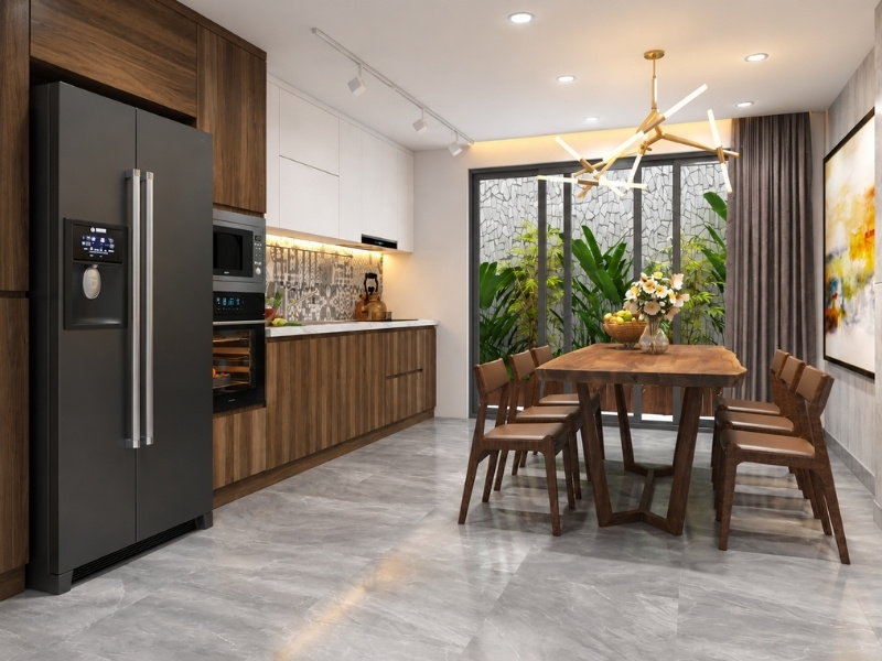 Khu bếp nhà phố 5x20m bố trí bàn ăn gỗ cạnh cửa kính thông ra sân vườn sau nhà