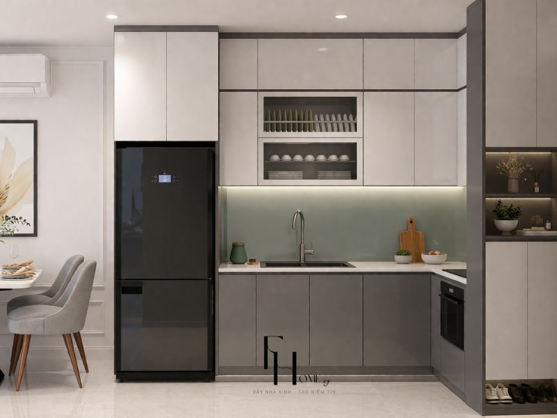 Phòng bếp chung cư 55m2 bố cục chữ L với tủ xám nhạt và xám anthracite, kính ốp tường xanh bạc hà và hốc kính mở trưng bày