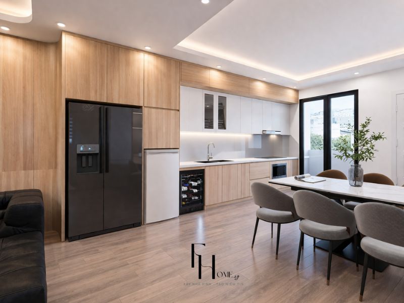 Phòng bếp chung cư 55m2 phong cách hiện đại với tủ bếp gỗ sáng, tủ lạnh đen tích hợp và bàn ăn mặt đá trắng