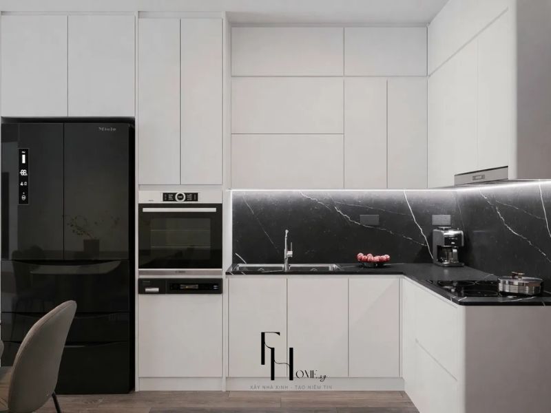 Bếp chung cư 68m2 toàn trắng mờ kịch trần tương phản ốp tường đá đen vân trắng, tủ lạnh đen Miele và lò nướng âm tường