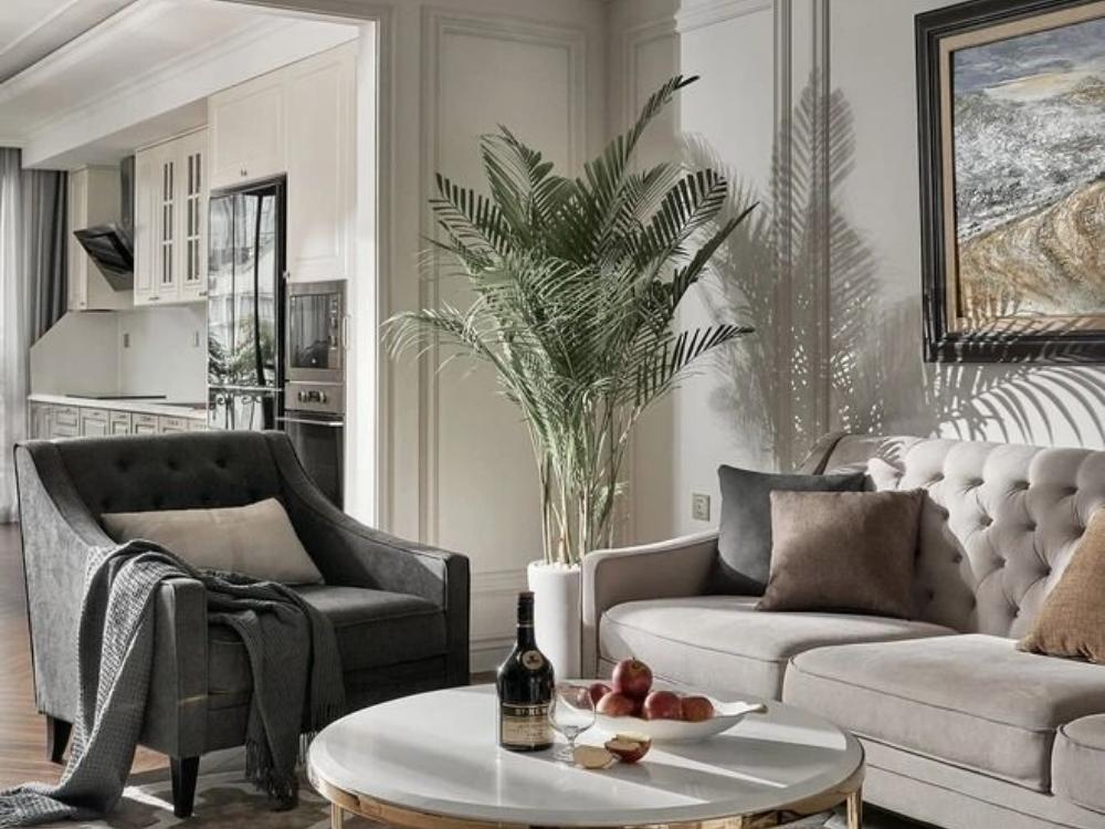 Phòng khách Tân cổ điển với các chi tiết trang trí phào chỉ, mạ vàng, nội thất cao cấp như gỗ tự nhiên và đá hoa cương, tạo không gian tinh tế và sang trọng.