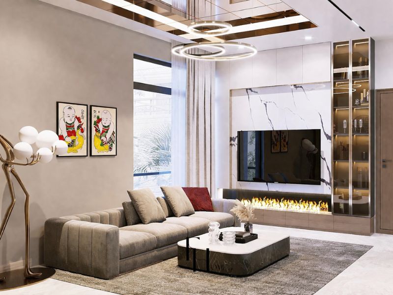 Phòng khách chung cư 100m2 phong cách tối giản với sofa xám be, tường TV ốp marble trắng vân đen và đèn vòng tròn kim loại đồng