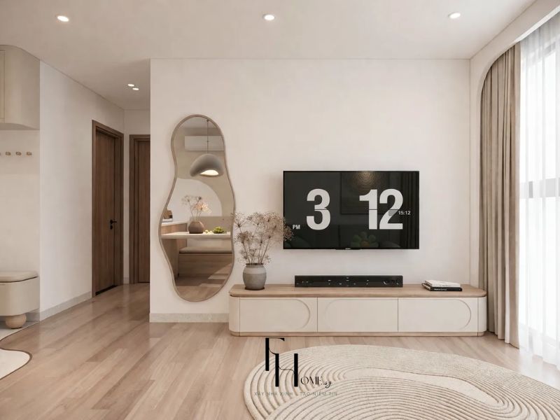 Phòng khách chung cư 68m2 với kệ TV thấp be mờ, gương hữu cơ khung gỗ sáng và thảm tròn vân đồng tâm be nhạt