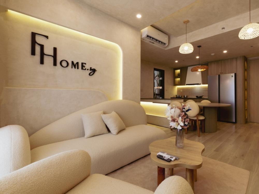 Phòng khách phong cách Wabi Sabi với không gian mở liền kề phòng bếp, sử dụng gam màu đất trầm ấm và vật liệu tự nhiên mang nét mộc mạc, thư giãn