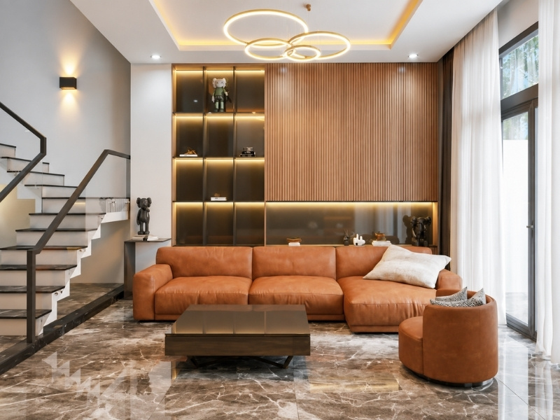 Phòng khách tone sáng với sofa da màu cam đất, vách lam gỗ và đèn trần hiện đại