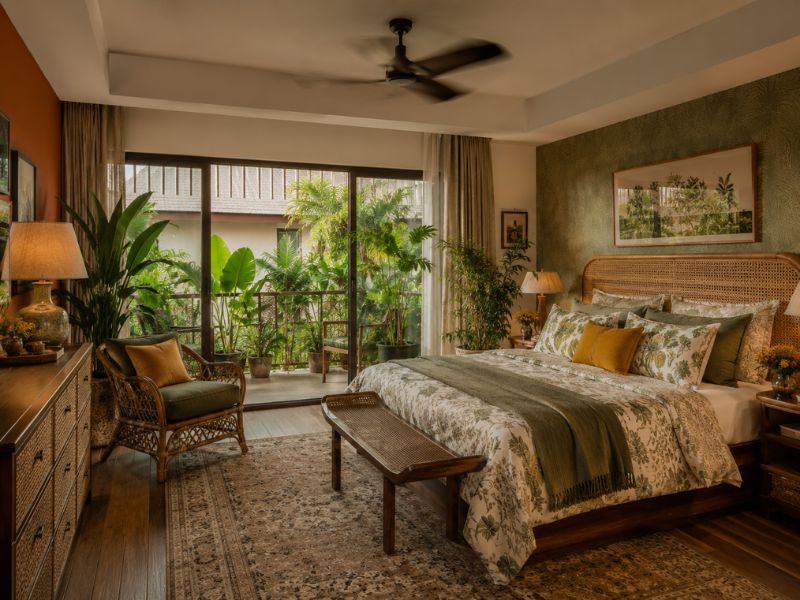 Phòng ngủ phong cách Tropical Maximalist với giấy dán tường lá, ga gối họa tiết thực vật và nội thất gỗ mây