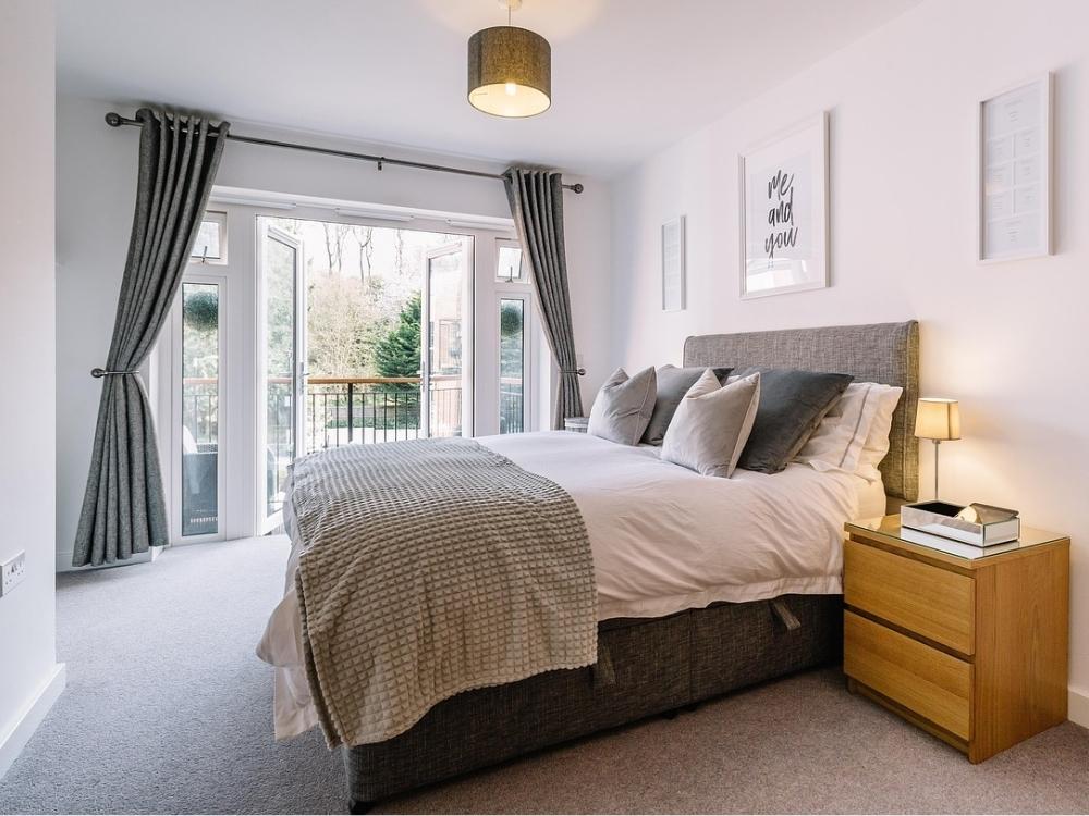 Thiết Kế Nội Thất Nhà Phố 2 Tầng Diện Tích 5x10m với phòng ngủ gọn gàng, giường có ngăn kéo và bàn làm việc