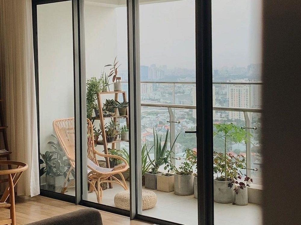 Ban công chung cư mini garden với cây xanh, hoa trang trí và ghế ngồi thư giãn tạo không gian xanh mát và dễ chịu.