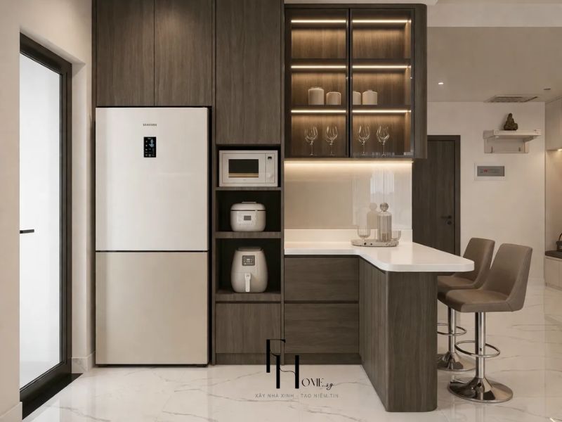 Phòng bếp chung cư 68m2 3 phòng ngủ tủ gỗ nâu đậm tủ kính đèn LED, bếp đảo ngắn đá trắng ghế bar da nâu thay bàn ăn cố định