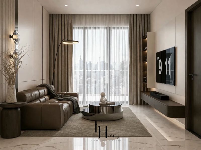Phòng khách chung cư 68m2 3 phòng ngủ sofa da nâu đậm tufted, bàn trà tròn inox đánh bóng và đèn sàn cần cong vàng đồng
