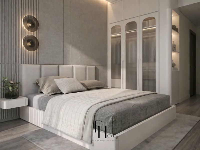 Phòng ngủ master 2 chung cư 68m2 3 phòng ngủ tường ốp nỉ xám nan gỗ dọc, đèn tường đĩa đồng thau và tủ trắng cánh kính sóng vòm cung kịch trần