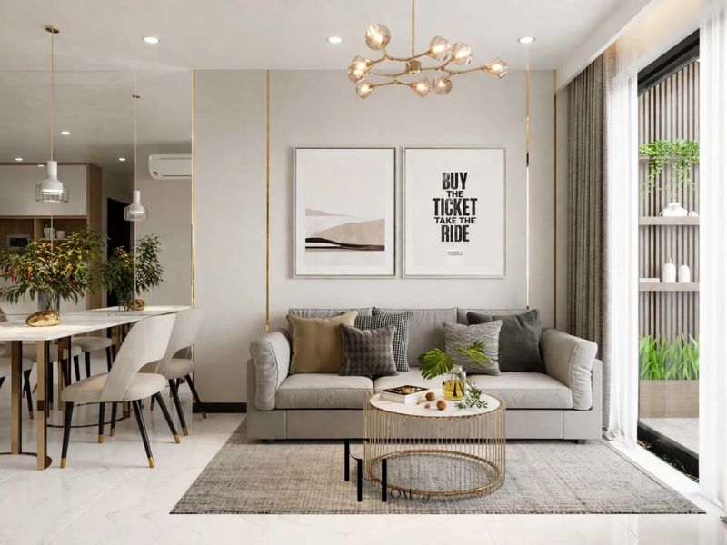 Phòng khách chung cư 77m2 tông xám be đường chỉ mạ vàng dọc tường ghế sofa xám bàn trà khung vàng bộ tranh đôi