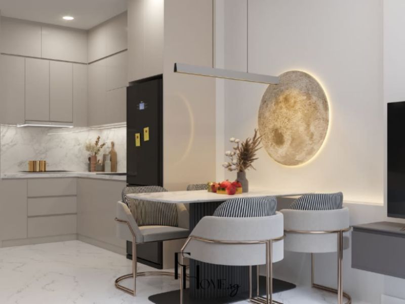 Phòng bếp chung cư 50m2 phong cách Hiện đại với hệ tủ chữ L cánh phẳng xám be matte, sàn và backsplash đá marble trắng, bàn ăn mặt đá và đèn thả đĩa tròn vàng đồng