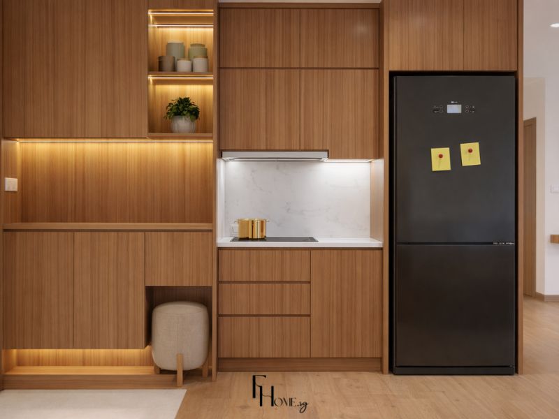 Phòng bếp chung cư 50m2 phong cách Nhật Bản với hệ tủ veneer vân dọc tông nâu ấm từ sàn lên trần, mặt bàn đá marble trắng, kệ hở đèn LED và tủ lạnh đen matte