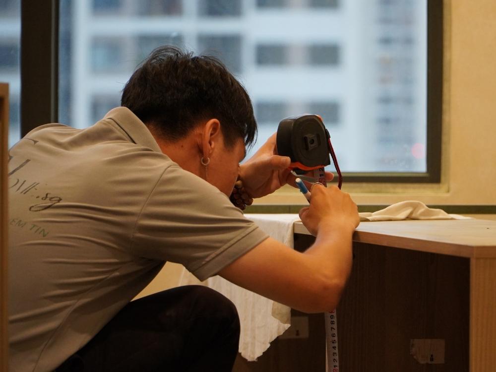 Thợ thi công FHome.sg đang làm việc tại công trình, thể hiện kỹ năng chuyên môn cao và sự tỉ mỉ trong quá trình lắp đặt nội thất