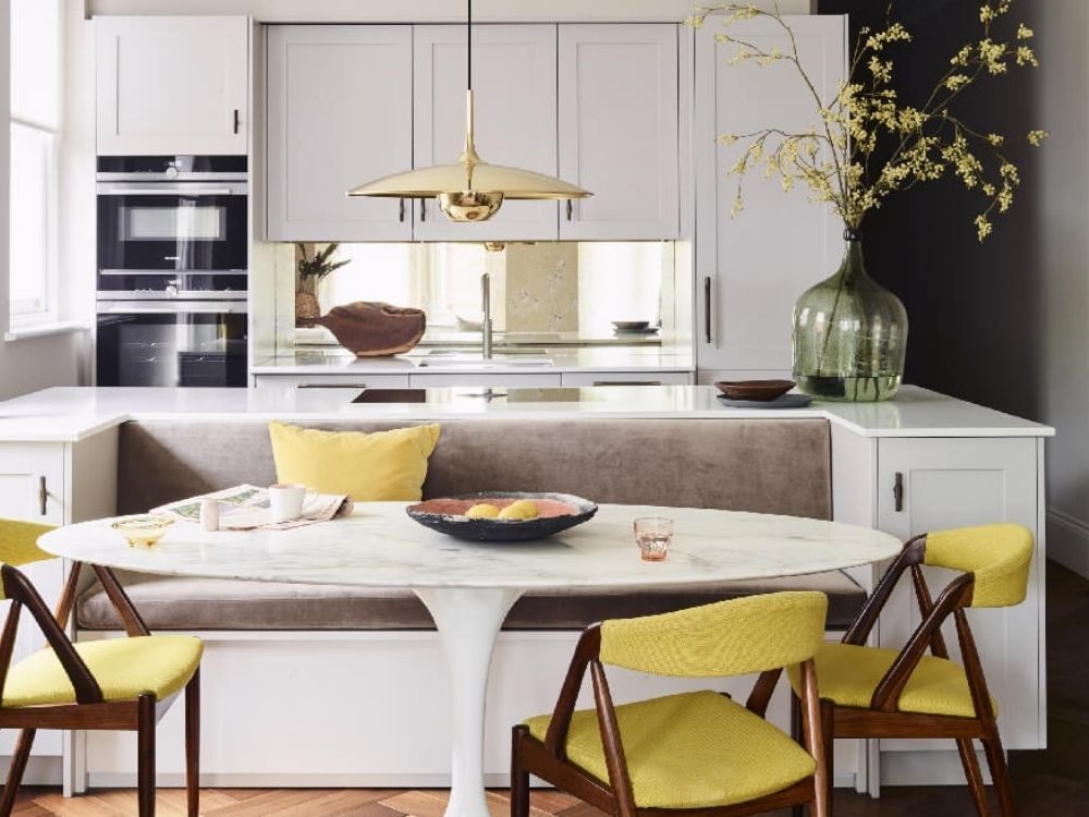 Bếp đảo kết hợp ghế băng bọc nỉ xám, ghế gỗ bọc nệm vàng, bàn oval đá marble