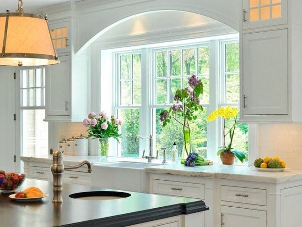 Bồn rửa lớn, mặt bàn đá trắng, khung cửa vòm, trang trí chậu hoa