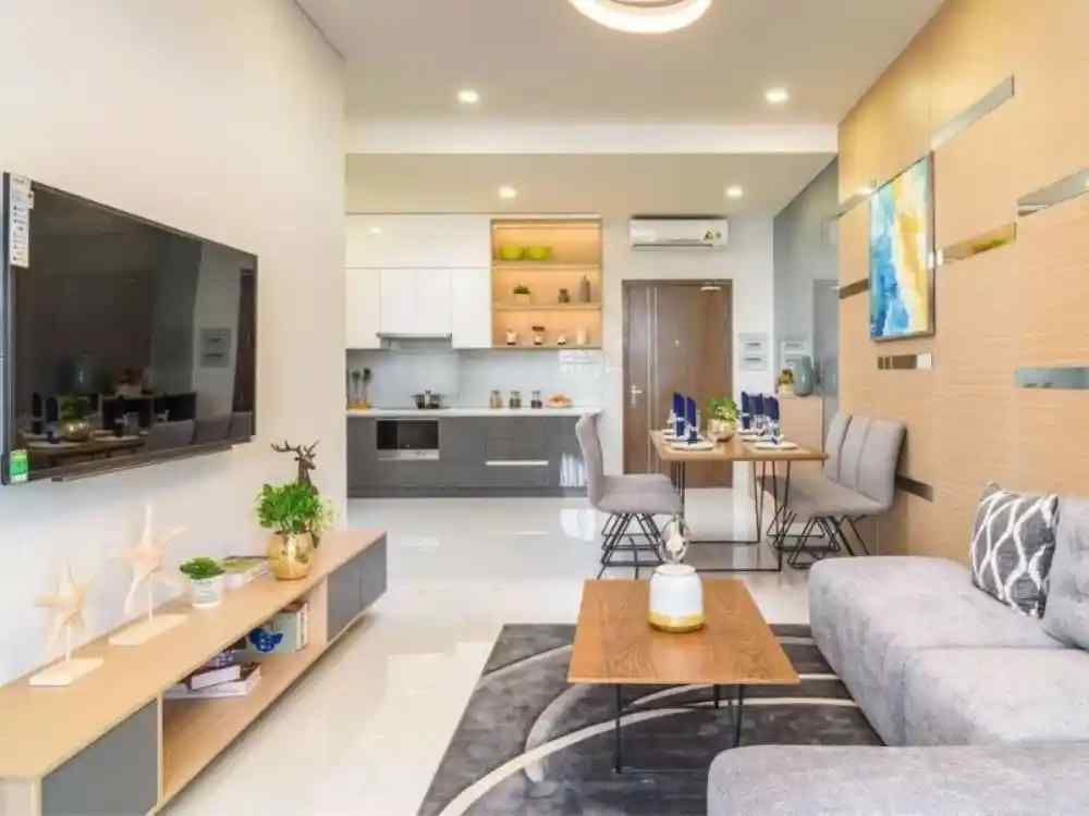 Không gian phòng khách liền bếp sáng sủa, nội thất gỗ sáng màu kết hợp sofa xám nhã nhặn