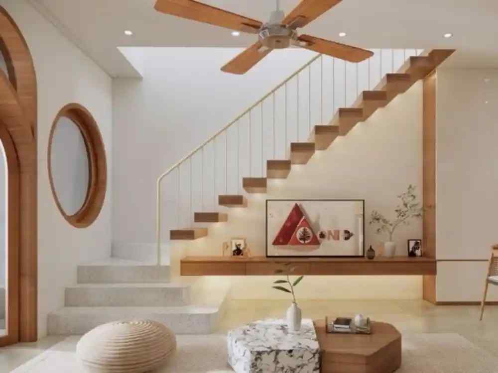 Không gian phòng khách tối giản với cầu thang bay gỗ sáng, tường trắng, quạt trần và bàn trà đá tự nhiên