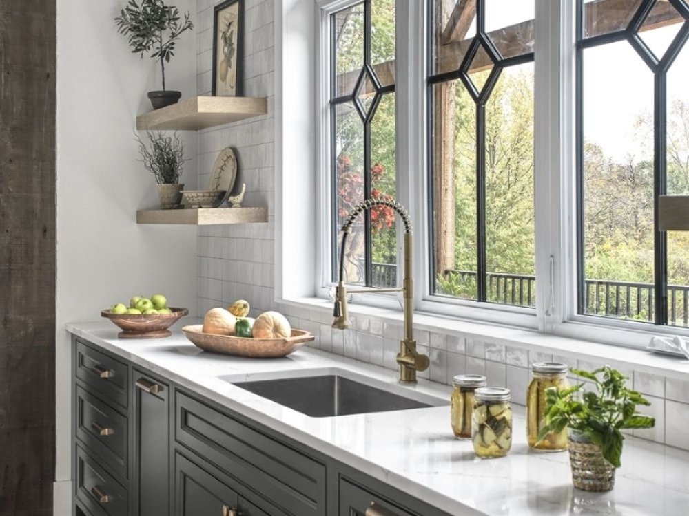 Khu vực rửa với mặt bàn đá sáng, vòi nước kim loại, bệ cửa sổ thoáng