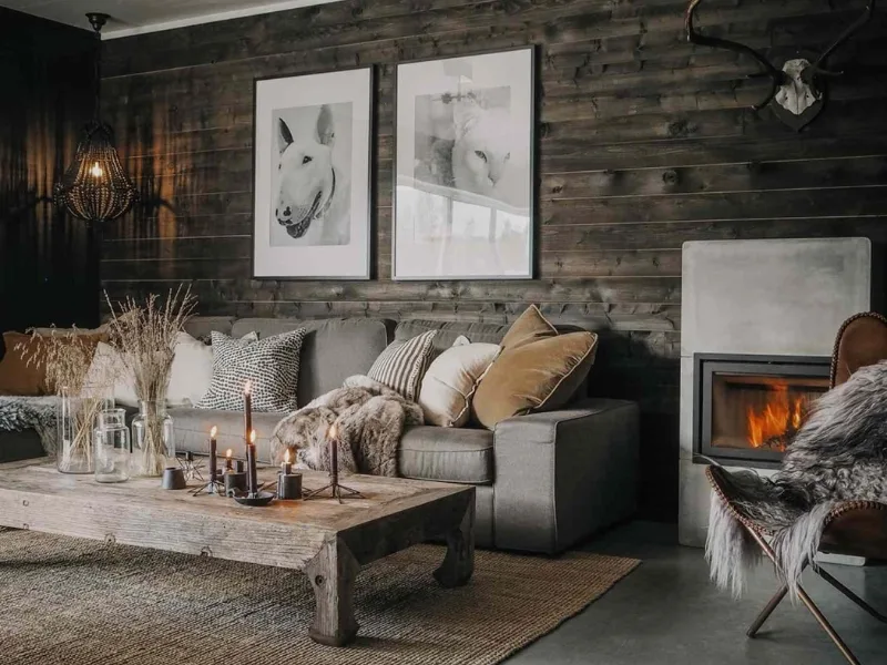 Nội thất phòng khách phong cách Bắc Âu phối tường gỗ sẫm với sofa phủ vải dệt cạnh lò sưởi.