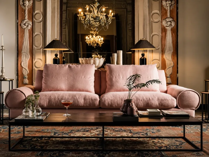 Nội thất phòng khách phong cách lãng mạn có sofa hồng dưới đèn chùm cổ điển cạnh rèm vải dày.