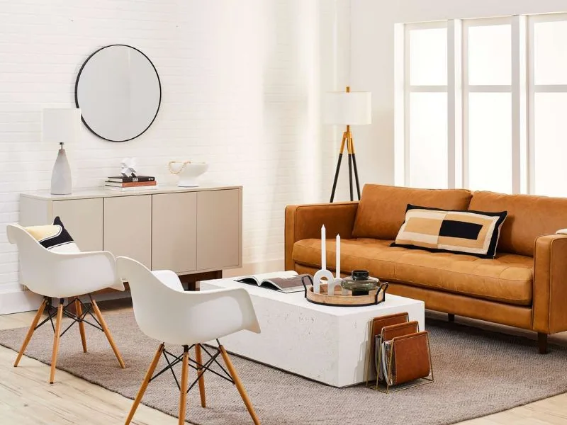 Thiết kế nội thất phòng khách phong cách hiện đại phối sofa màu cam với ghế trắng trong không gian nhiều ánh sáng.
