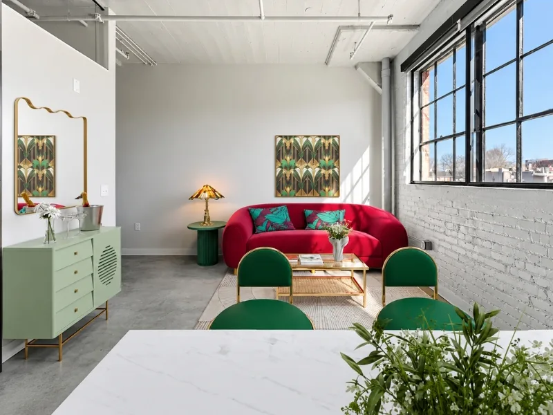 Nội thất phòng khách phong cách Retro phối sofa đỏ cùng ghế xanh bên tủ màu pastel.