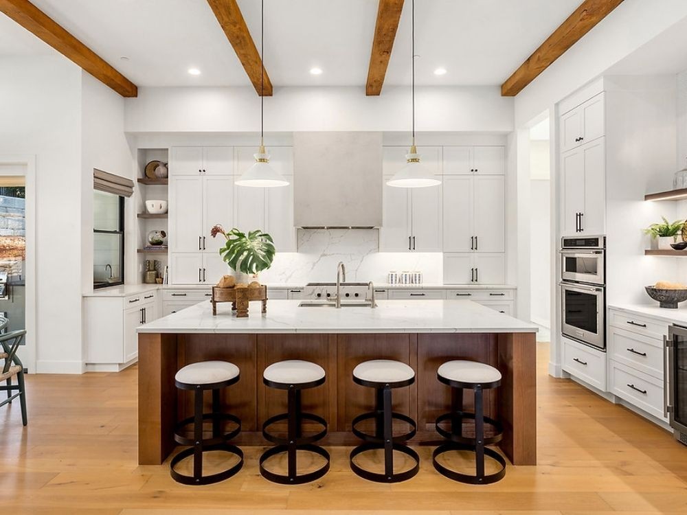 Phòng bếp đa năng phong cách hiện đại với đảo bếp kết hợp bàn ăn, tủ trắng cao sát trần