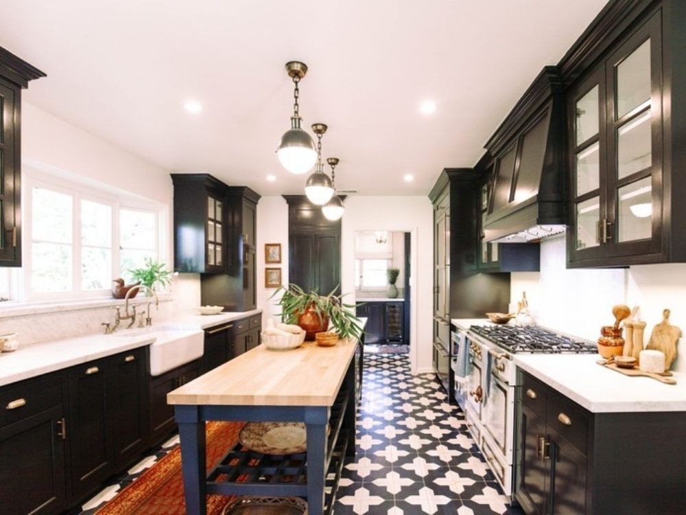 Phòng bếp Indochine với sàn gạch xi măng họa tiết hình học, tủ bếp màu xanh rêu