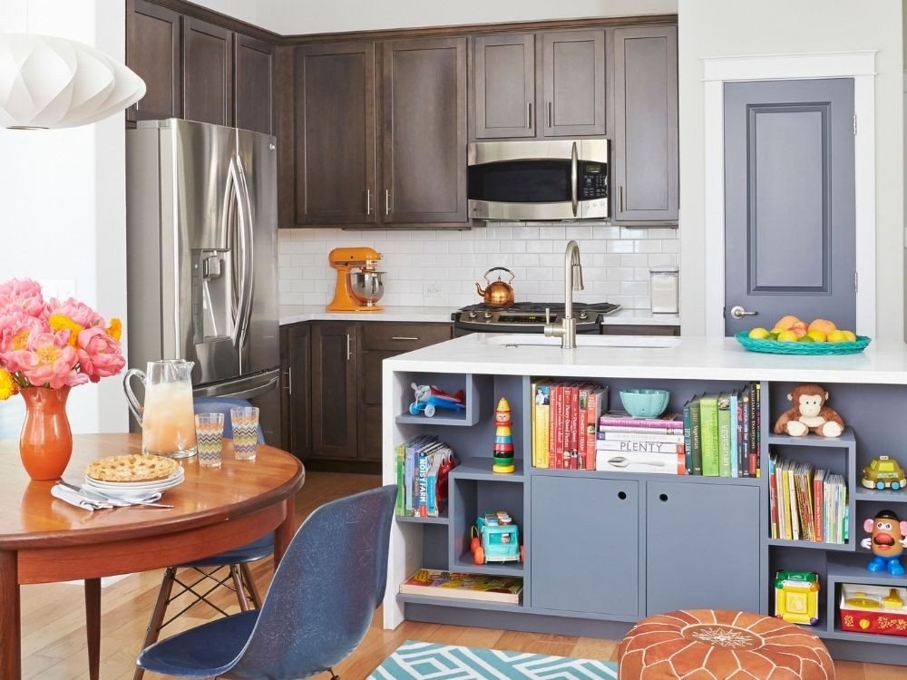 Phòng bếp nối liền phòng khách, tủ bếp gỗ sẫm, đảo bếp tích hợp kệ sách