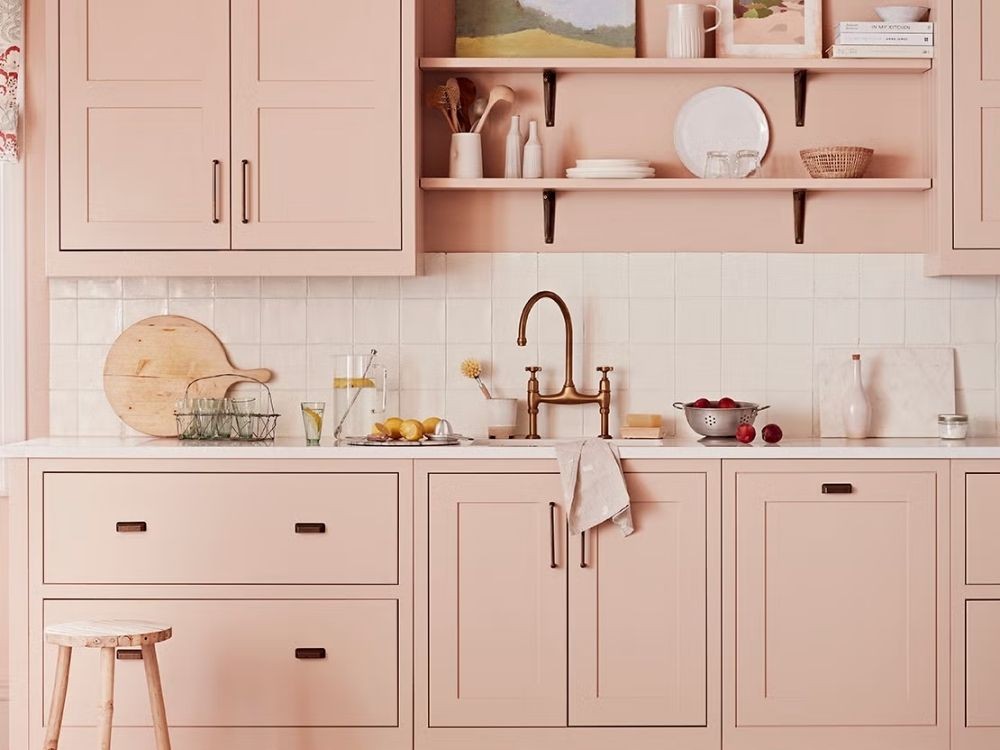 Phòng bếp tủ bếp chữ I màu hồng phấn, gạch ốp vuông trắng, kệ mở trang trí