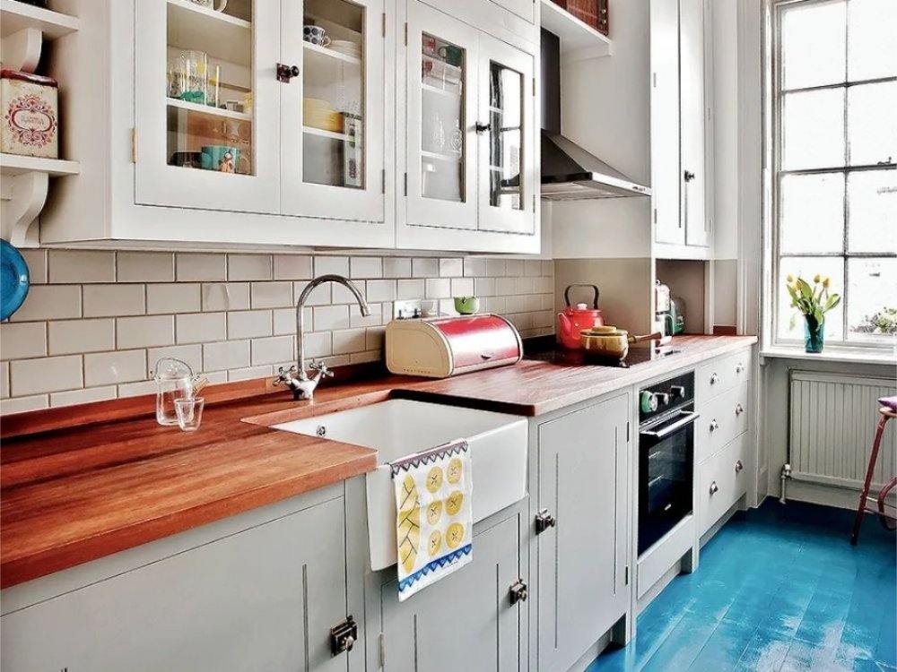 Phòng bếp tủ bếp chữ I màu xám sáng, mặt bếp gỗ, tường ốp gạch subway trắng