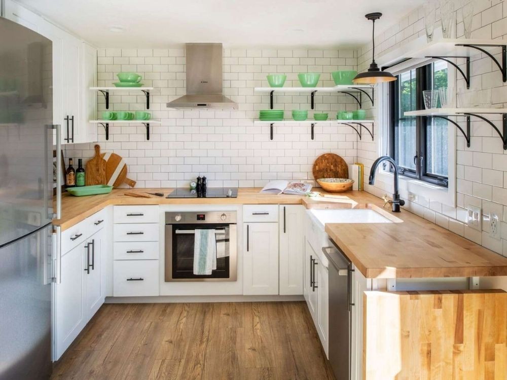 Phòng bếp tủ bếp chữ U trắng, mặt gỗ sáng, kệ mở đen treo tường