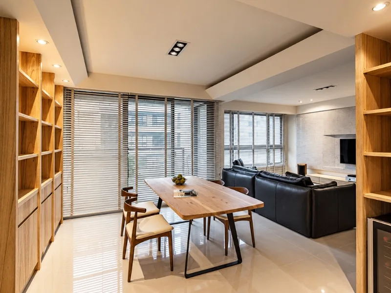 Phòng khách phong cách Đài Loan đặt sofa tối màu cạnh bàn ăn và hệ kệ gỗ cao.