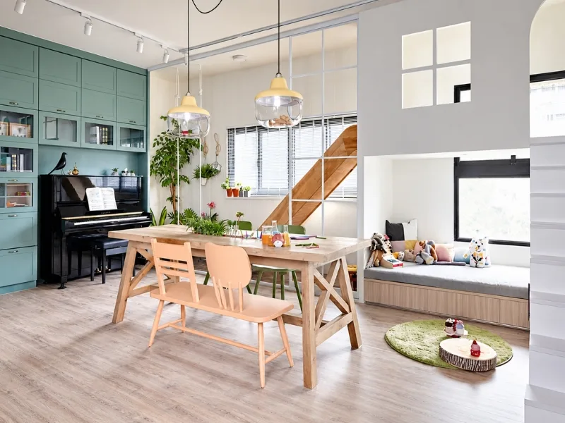 Phòng khách phong cách Đài Loan phối nội thất pastel quanh bàn ăn gỗ gần cầu thang trắng.