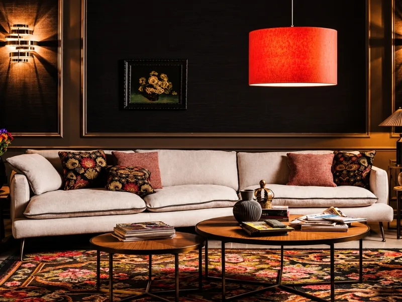 Phòng khách phong cách lãng mạn phối sofa hồng nhạt với đèn chụp đỏ trên nền tường đen.