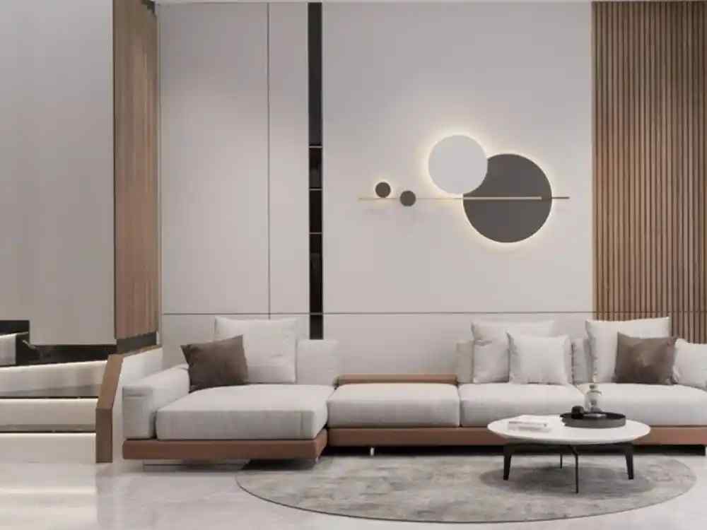 Phòng khách nhà ống hiện đại với sofa chữ L màu xám nhạt, đèn tường hình tròn nghệ thuật và tường ốp gỗ tối giản