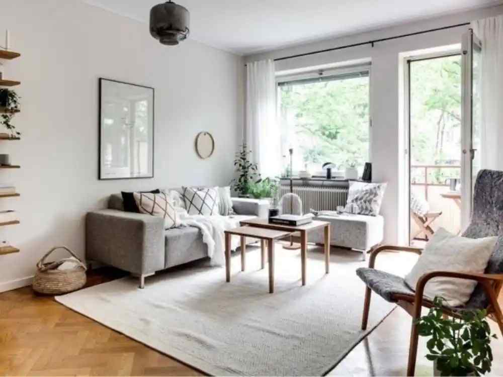 Phòng khách phong cách Scandinavian với sofa xám sáng, bàn trà gỗ mộc mạc, cửa sổ lớn đón ánh sáng
