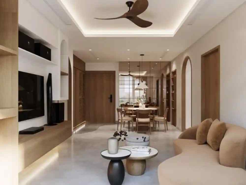 Phòng khách phong cách Wabi Sabi với sofa cong nệm be, bàn trà gỗ tròn và quạt trần cánh gỗ