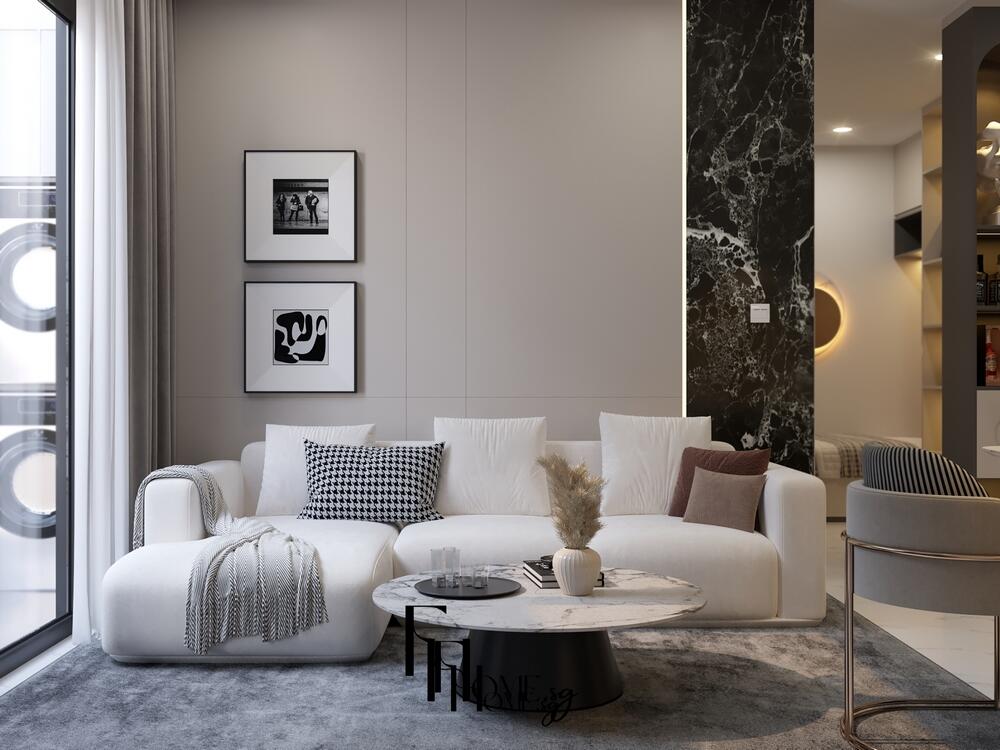 Phòng khách tối giản với sofa trắng, bàn tròn đá và tranh treo tường đen trắng hiện đại