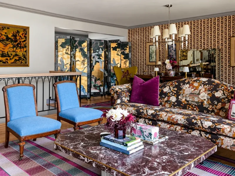 Thiết kế phòng khách phong cách Vintage phối sofa hoa với ghế xanh bên bàn trà mặt vân đá.